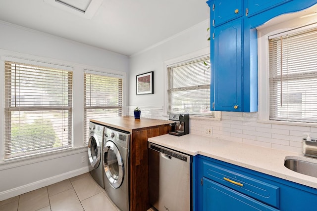 5011 Eilers Ave, Austin, TX 78751 - laundry area featuring washer and dryer, light tile patterned floors, ornamental molding, a sink, and baseboards