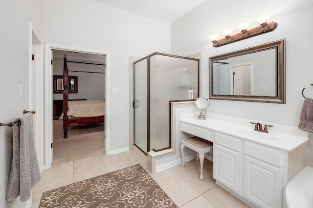 bathroom featuring tile patterned flooring, baseboards, a stall shower, and vanity