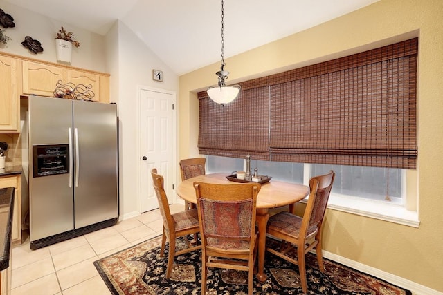 dining space with light tile patterned flooring and lofted ceiling