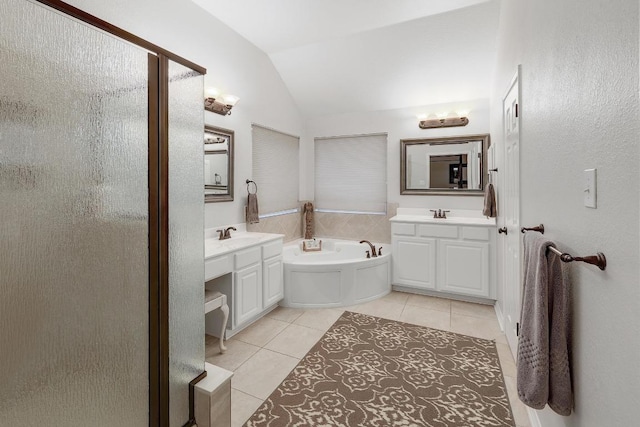 full bathroom with a bath, tile patterned floors, vaulted ceiling, and two vanities