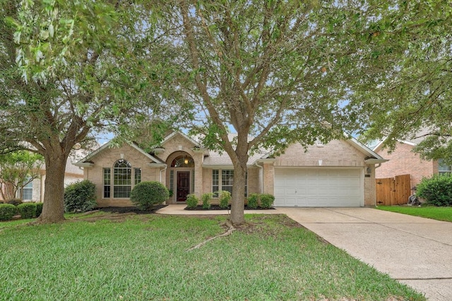view of front of property with driveway, a front yard, a garage, brick siding, and fence