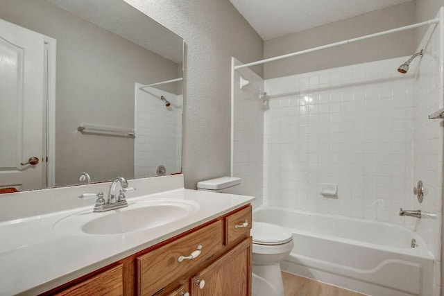 full bathroom with shower / bathing tub combination, wood finished floors, vanity, toilet, and a textured wall