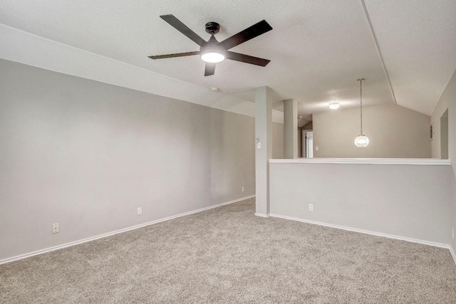 carpeted empty room featuring a ceiling fan, baseboards, and lofted ceiling