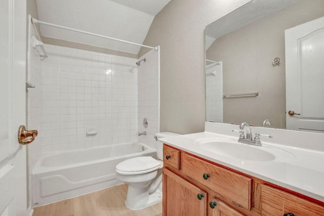 full bathroom featuring shower / tub combination, vanity, toilet, wood finished floors, and lofted ceiling