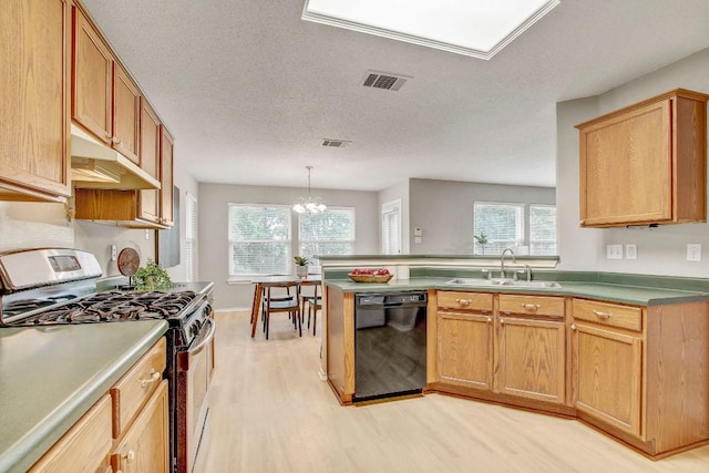 kitchen with visible vents, stainless steel gas stove, black dishwasher, under cabinet range hood, and a sink