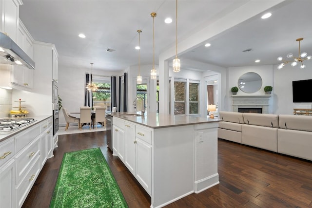kitchen featuring dark wood-style flooring, stainless steel appliances, open floor plan, and a sink