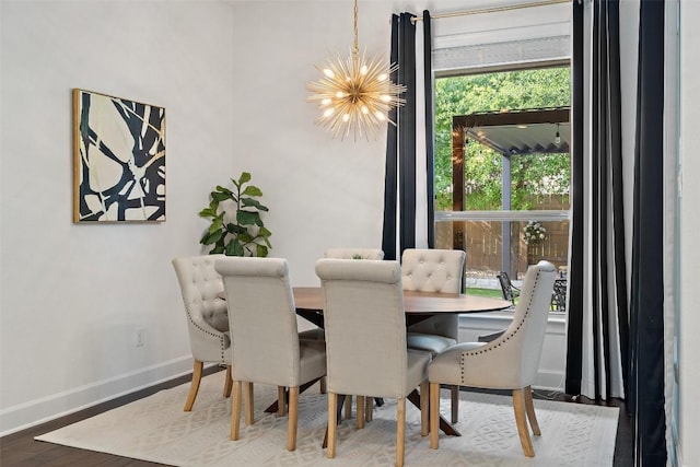 dining space featuring baseboards, wood finished floors, and a notable chandelier