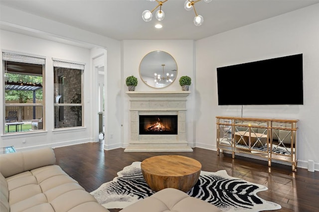 living room with a chandelier, baseboards, a glass covered fireplace, and wood finished floors