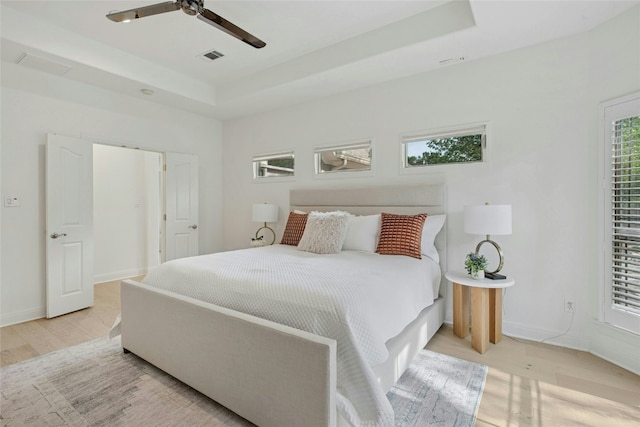 201 Explorer, Lakeway, TX 78734 - bedroom with light wood-type flooring, a raised ceiling, baseboards, and ceiling fan