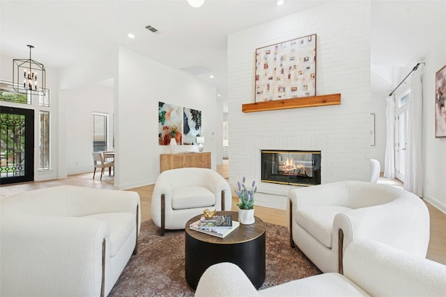 201 Explorer, Lakeway, TX 78734 - living area with a chandelier, wood finished floors, a brick fireplace, and recessed lighting