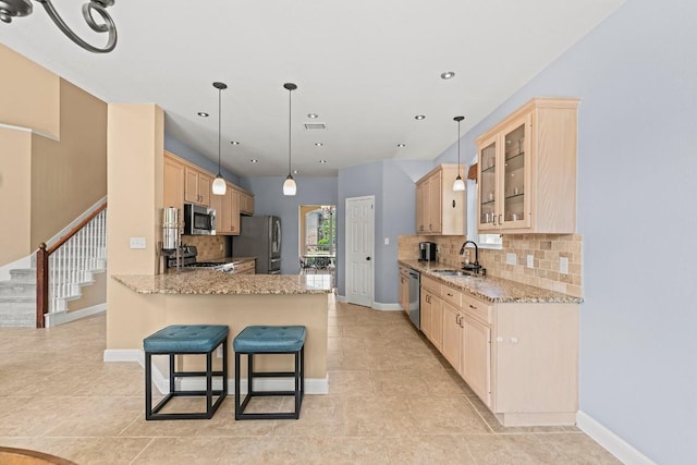 kitchen featuring decorative backsplash, a peninsula, light tile patterned floors, and stainless steel appliances