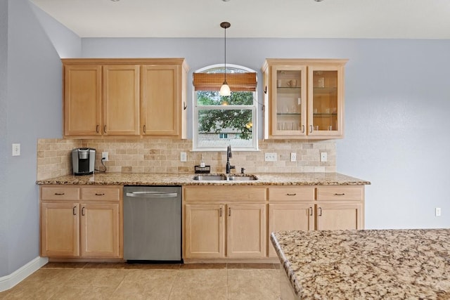 kitchen featuring light brown cabinetry, light stone countertops, a sink, dishwasher, and decorative backsplash