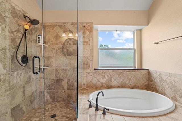 bathroom featuring a bath and a tile shower
