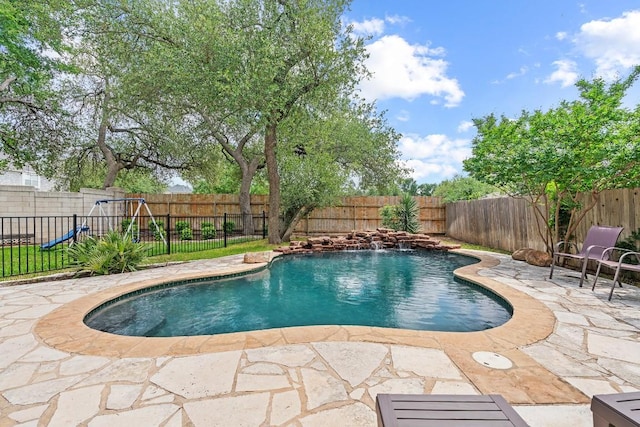 view of pool with a patio, a fenced in pool, a fenced backyard, and a playground