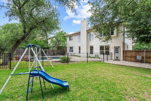 view of jungle gym featuring a fenced backyard, a patio, and a yard