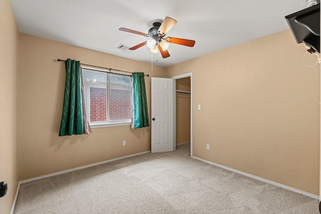 unfurnished bedroom featuring baseboards, visible vents, ceiling fan, and carpet