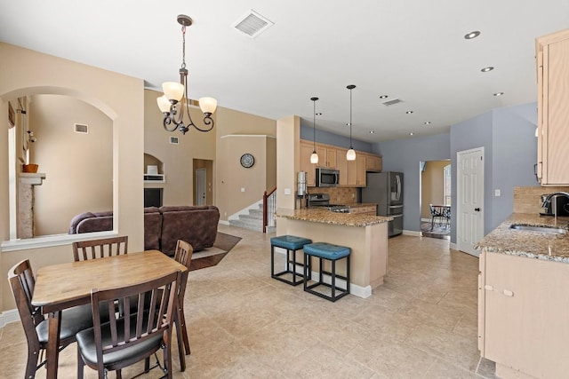 dining room with visible vents, arched walkways, baseboards, and a notable chandelier