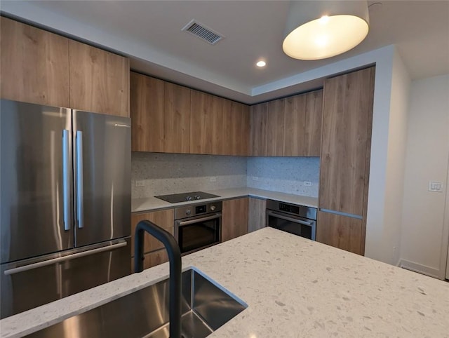 84 E Ave Unit 2207, Austin, TX 78701 - kitchen with appliances with stainless steel finishes, modern cabinets, visible vents, and light stone counters