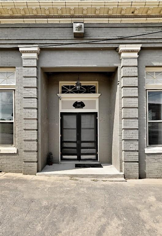 doorway to property with brick siding