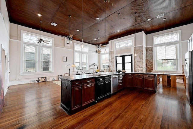 kitchen featuring dark wood-style flooring, appliances with stainless steel finishes, a sink, and a towering ceiling