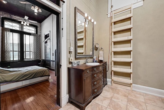 bathroom with baseboards, a ceiling fan, and vanity