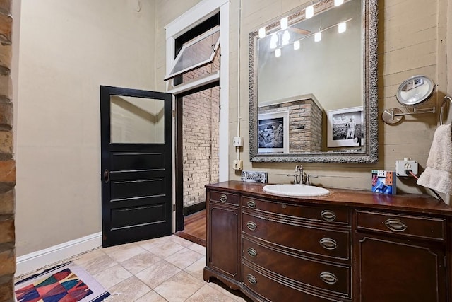 bathroom with baseboards, tile patterned floors, and vanity