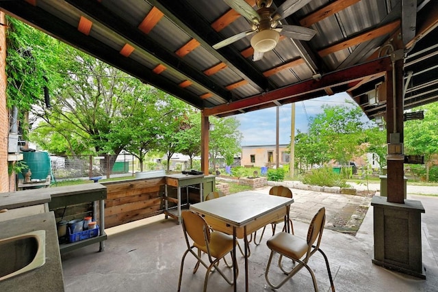 view of patio with a sink, a ceiling fan, and outdoor dining space