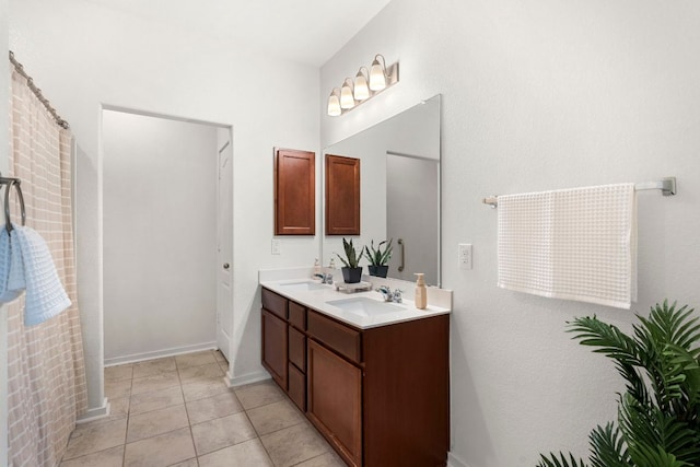full bath featuring double vanity, a sink, and tile patterned flooring