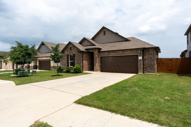 view of front facade featuring a front yard, brick siding, fence, an attached garage, and a shingled roof