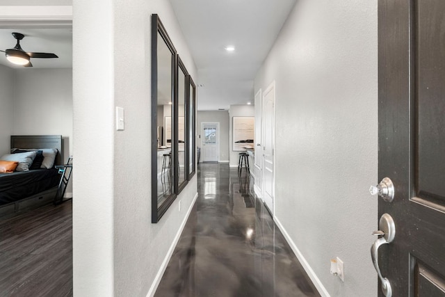 hall featuring baseboards and recessed lighting