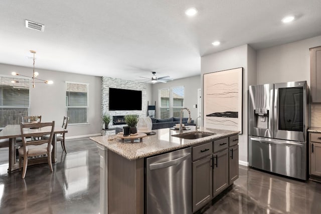 kitchen featuring ceiling fan, visible vents, concrete flooring, a sink, and stainless steel appliances
