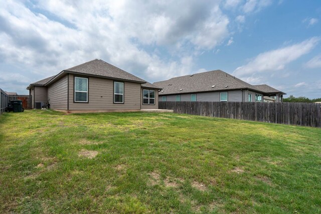 back of property featuring a yard, cooling unit, and a fenced backyard