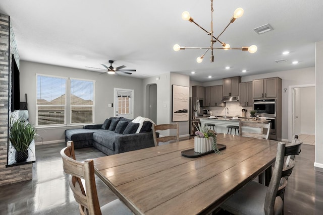 dining room featuring arched walkways, ceiling fan with notable chandelier, recessed lighting, baseboards, and visible vents