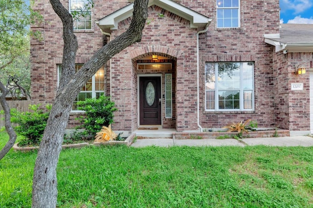 1205 Yountville Dr, Leander, TX 78641 - view of exterior entry featuring brick siding and a yard