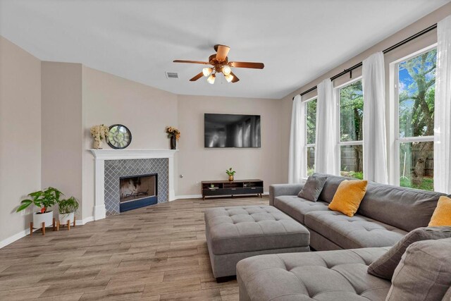 1205 Yountville Dr, Leander, TX 78641 - living area with light wood-style floors, ceiling fan, and a tiled fireplace