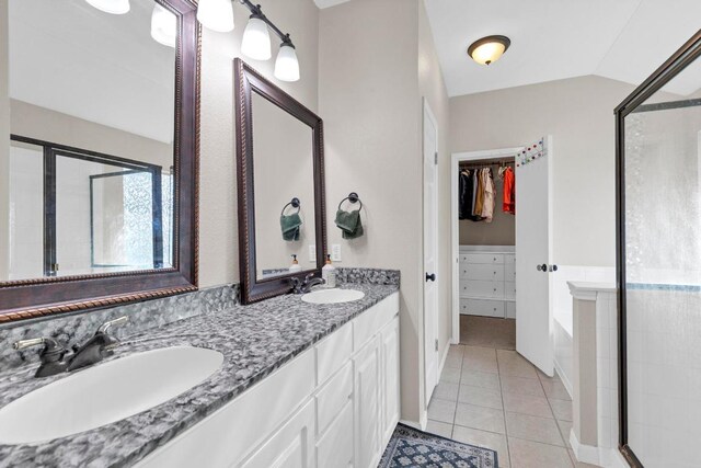 1205 Yountville Dr, Leander, TX 78641 - bathroom featuring a stall shower, a spacious closet, double vanity, tile patterned flooring, and a garden tub