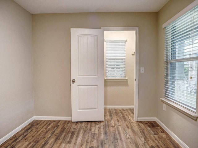 unfurnished room with baseboards and wood finished floors