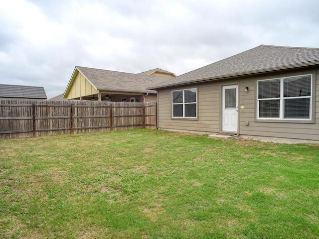 back of property featuring a fenced backyard and a yard