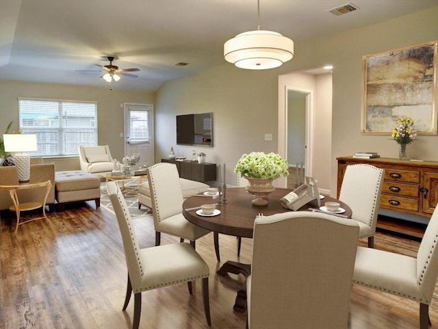 dining room featuring visible vents, ceiling fan, and wood finished floors