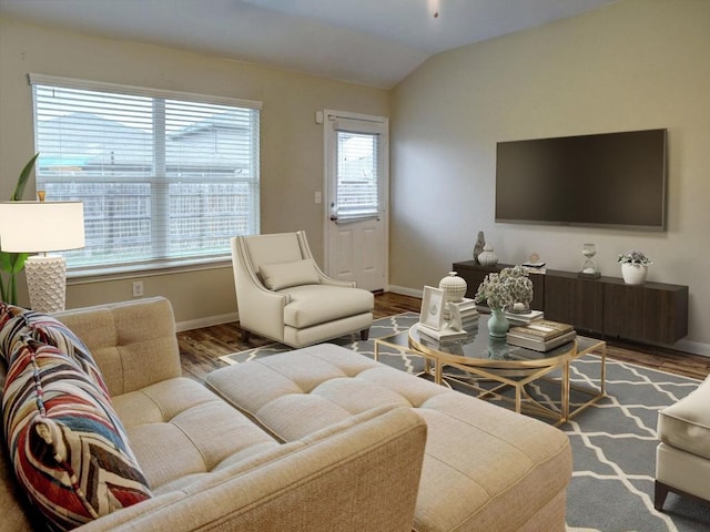 living area with baseboards, wood finished floors, and lofted ceiling
