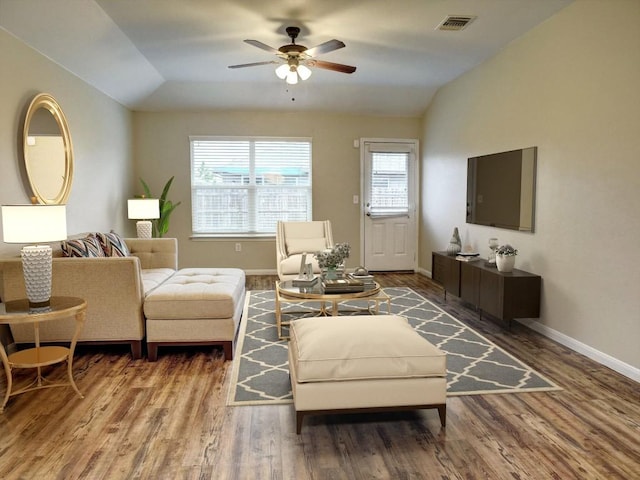 living area featuring plenty of natural light, a ceiling fan, vaulted ceiling, and wood finished floors