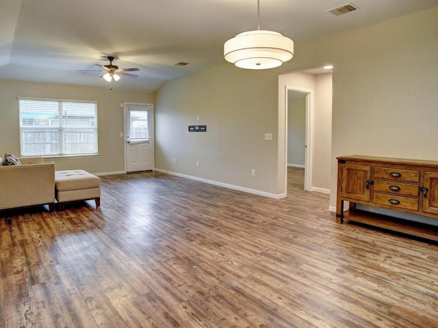 living room featuring baseboards, ceiling fan, wood finished floors, and visible vents