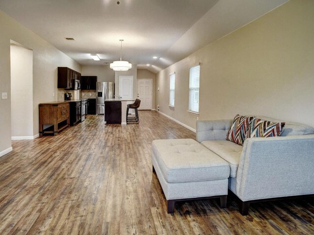14500 Callan Ct, Manor, TX 78653 - living room featuring dark wood-style flooring, lofted ceiling, and baseboards