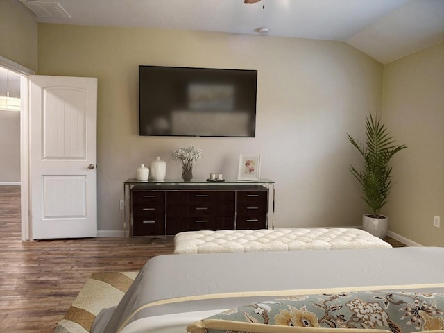 bedroom featuring baseboards, visible vents, dark wood-style floors, and lofted ceiling