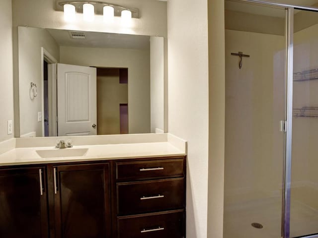 bathroom with vanity, visible vents, and a stall shower