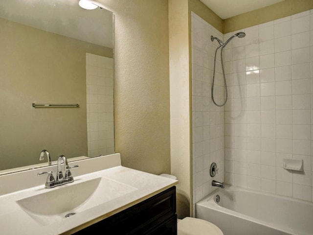 bathroom with washtub / shower combination, a textured wall, vanity, and toilet