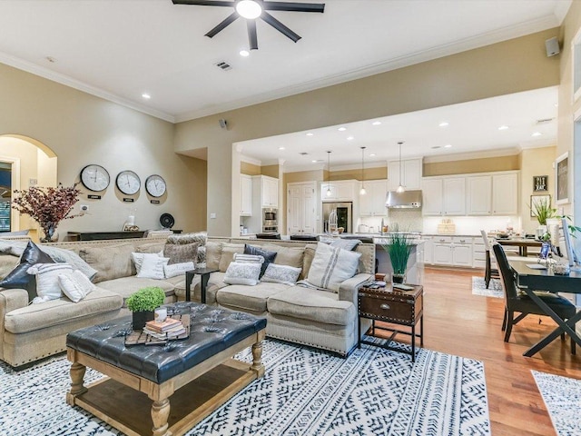 living area featuring a ceiling fan, visible vents, crown molding, recessed lighting, and light wood-style flooring
