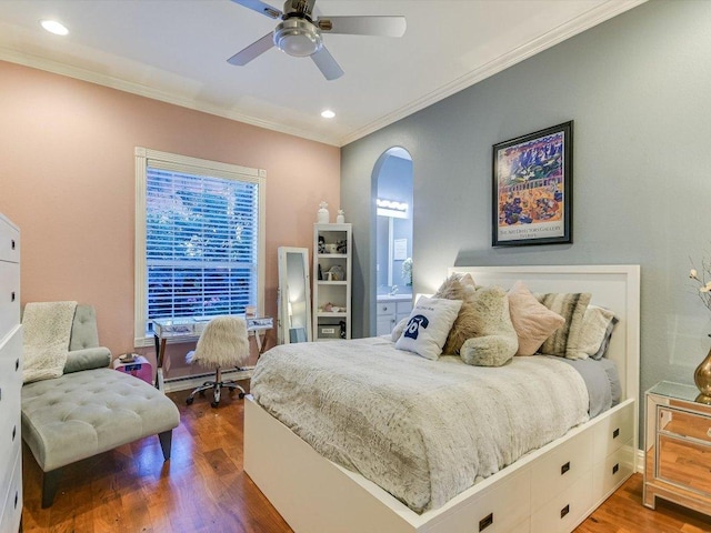 bedroom featuring crown molding, arched walkways, multiple windows, and wood finished floors
