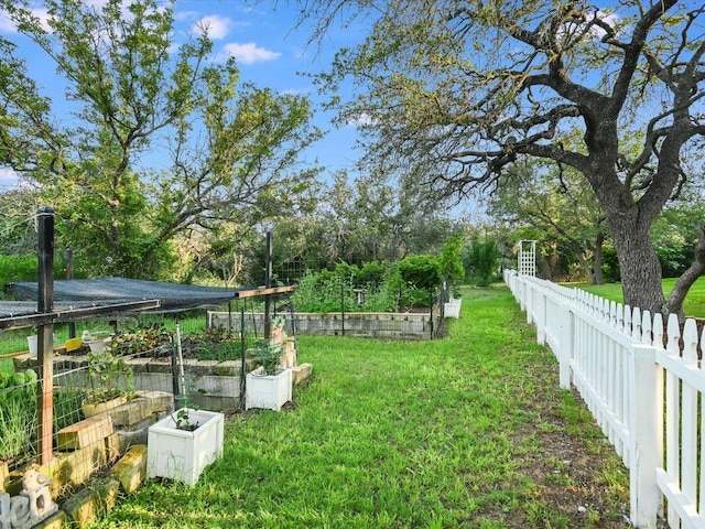 view of yard featuring fence and a vegetable garden