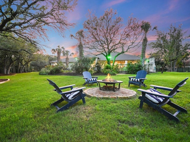 yard at dusk featuring an outdoor fire pit